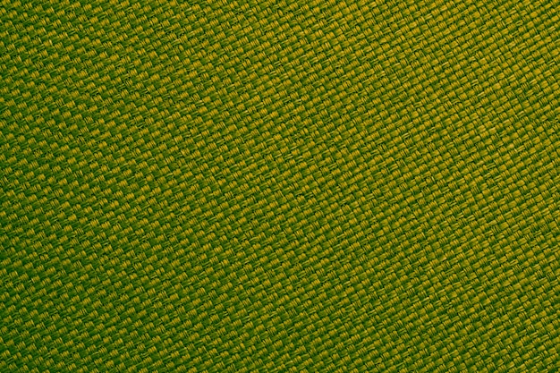 Yellow and green textile close-up. Woven fiber background, plaited cloth surface, natural burlap wallpaper. Macro linen material texture.