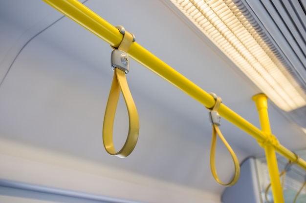 Yellow hand grip straps inside subway train