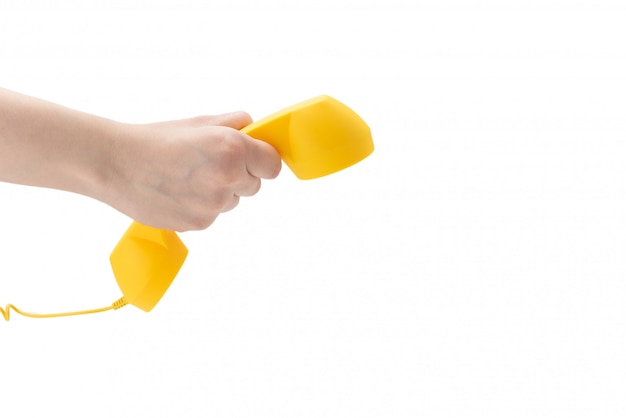 Yellow handset in woman hand isolated on white.