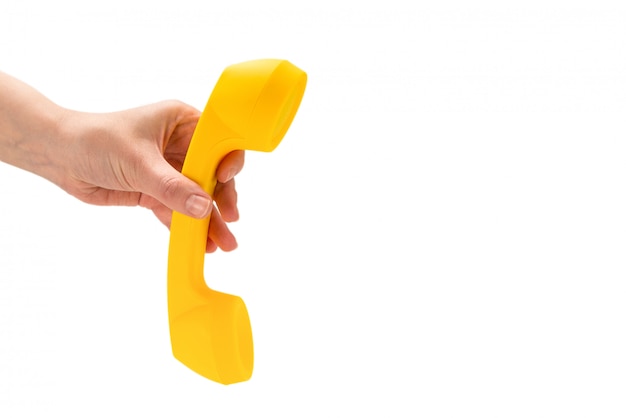 Yellow handset in woman hand isolated on white.