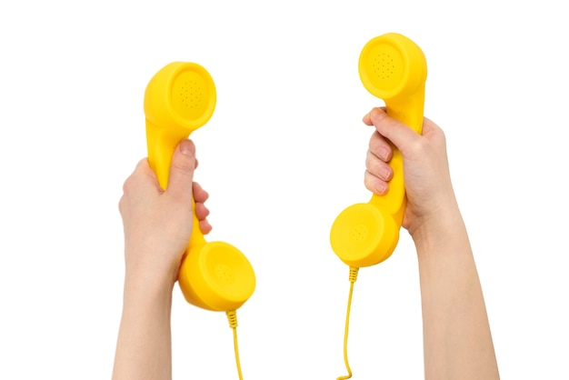 Yellow handset in woman hand isolated on white.