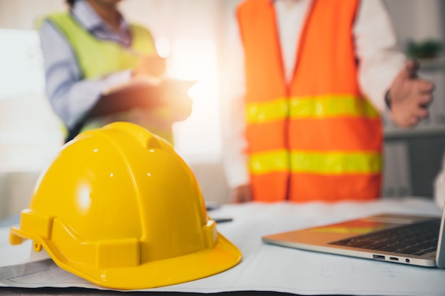 Yellow helmet of construction worker on meeting table