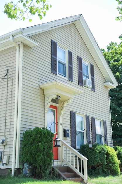 A yellow house with a red door and a red door.