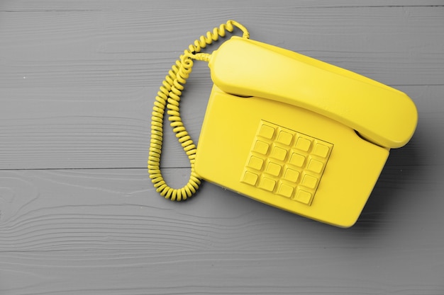 Yellow .landline phone on gray