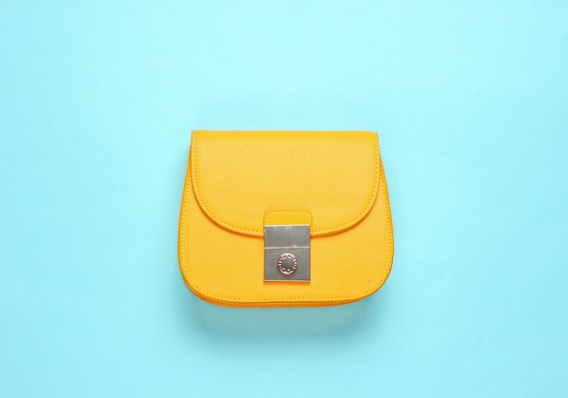 Yellow leather mini bag on blue surface