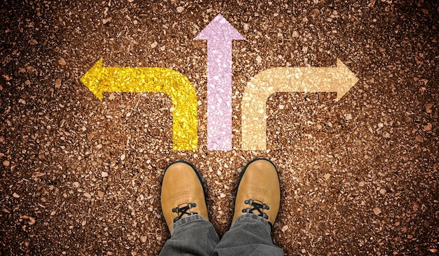 Photo yellow leather shoes and three colorful chalky arrows on ground strategy concept