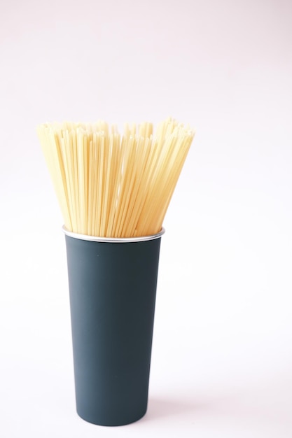 Yellow long spaghetti in a container on table