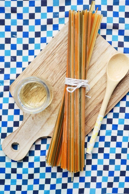 Yellow long spaghetti egg and oil on table