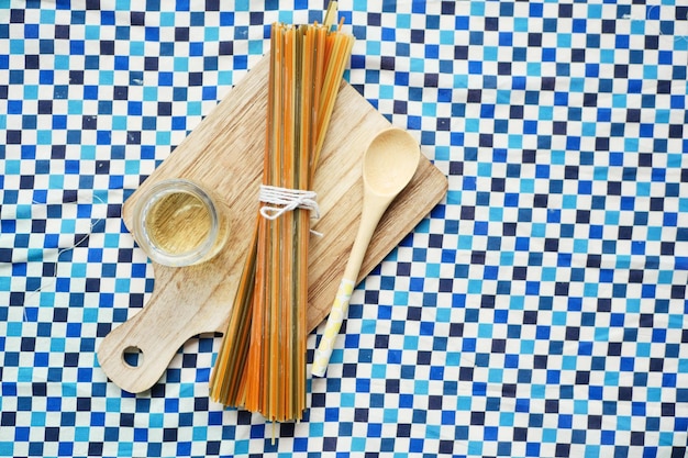 Yellow long spaghetti and oil on table