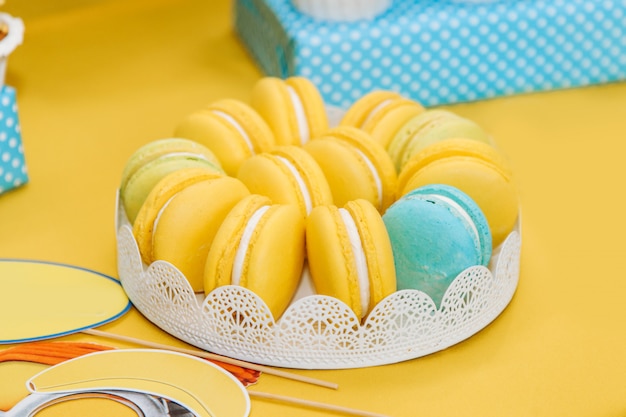 Yellow macaroons in a plate on the table