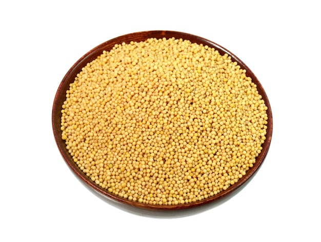 Yellow mustard seeds in wooden bowl isolated on white background