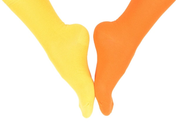 Yellow and orange socks on woman foot isolated on white background