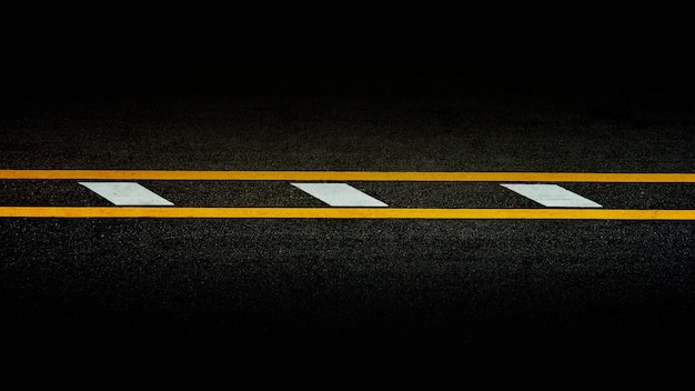 Photo yellow paint line on black asphalt. space transportation background