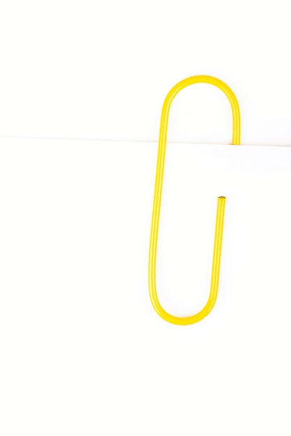 Yellow paper clip on a white background