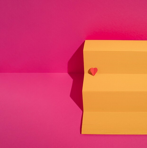 Photo yellow paper podium with red heart on magenta background minimal love or valentine concept