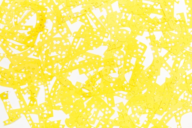 Yellow paper scraps from making confetti on a white background