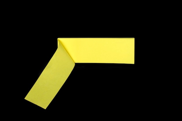 Yellow paper stick for notes with curled corner on black background