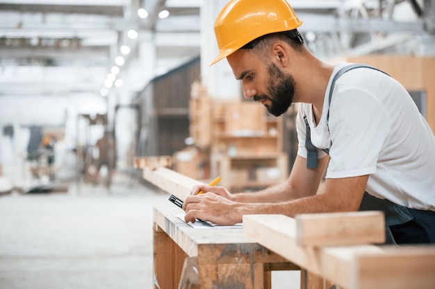 Yellow pen marks the area Industrial worker in wooden warehouse