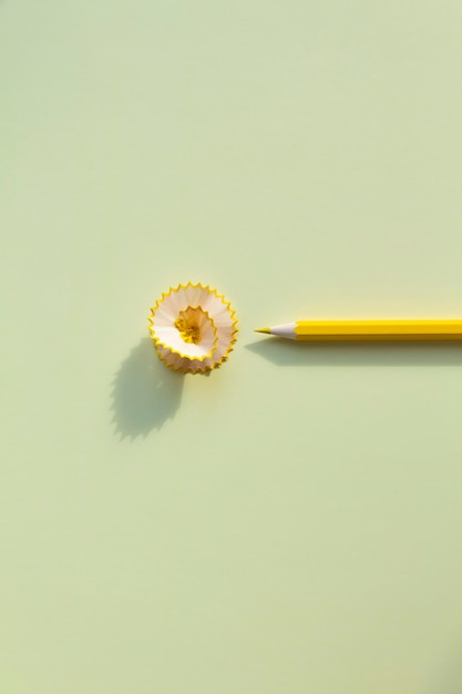 Yellow pencil with bright shavings and cleans on a yellow background