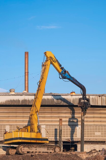 Yellow Pile drilling crawler crane working to install foundation in industrial construction site