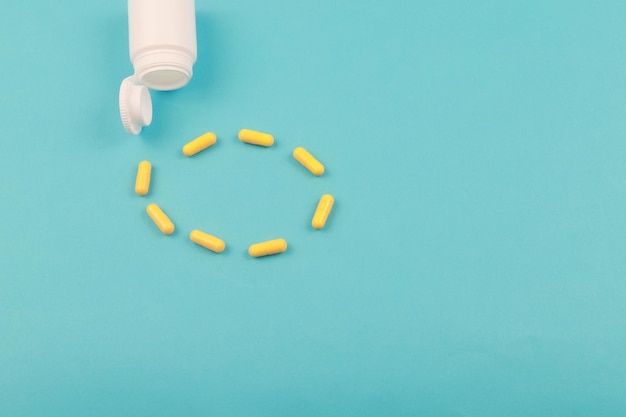 Yellow pills on blue background close up Blue background with copy space for text Healthy and medicine