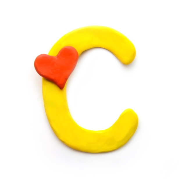 Yellow plasticine letter C English alphabet with red heart meaning love