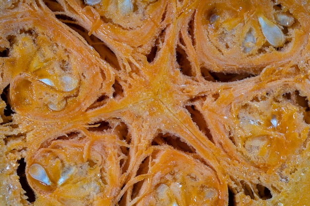 Yellow pumpkin cut in half with the texture of seeds and pulp Pumpkin slices background close up top view