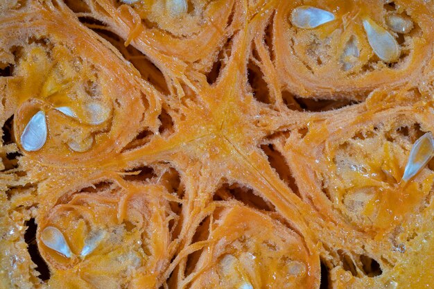 Yellow pumpkin cut in half with the texture of seeds and pulp Pumpkin slices background closeup top view