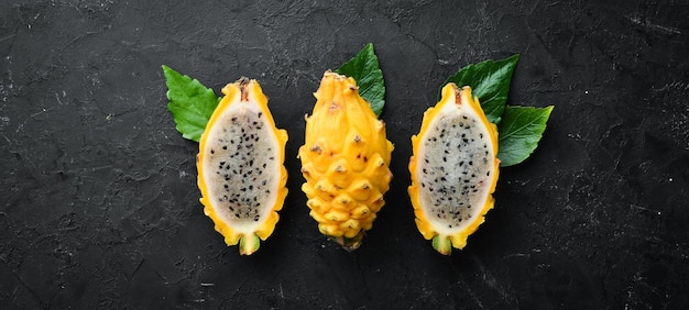 Yellow Pytahya on a black background Fruit Dragon Tropical Fruits Top view Free space for text