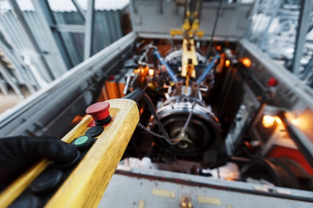 Yellow remote control of a crane with a red button