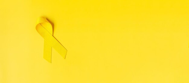 Photo yellow ribbon on yellow background for supporting people living and illness septembt