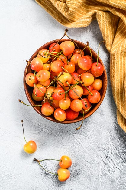 Yellow ripe cherries in a bowl.