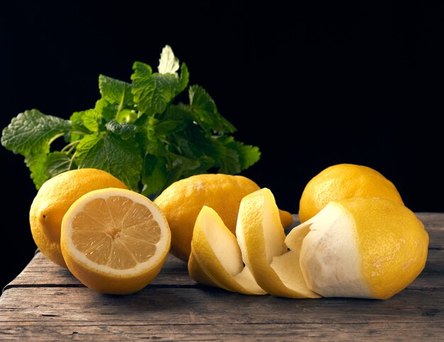 Yellow ripe lemon and a bunch of fresh green mint on a wooden bo