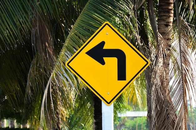 Yellow road sign - turn left in the countryside