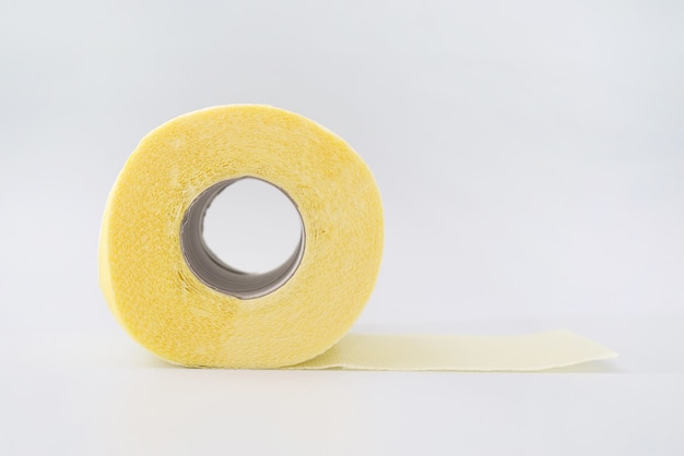 Yellow roll of toilet paper on a white background.