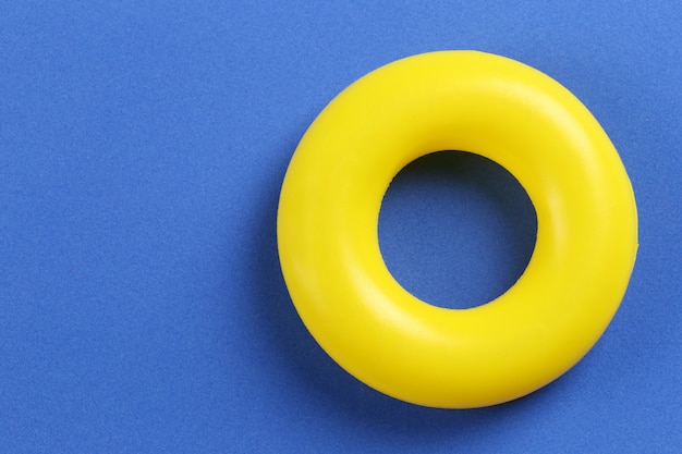 Photo yellow rubber ring placed on a blue paper background.