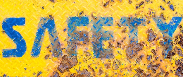 Yellow safety sign with rusted texture background