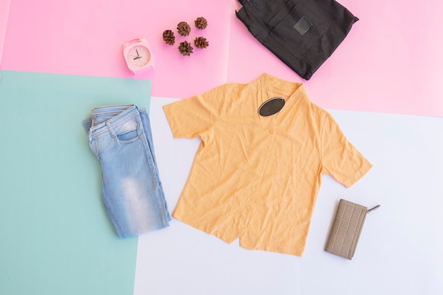 A yellow shirt and blue jeans on a background of various pastel colors