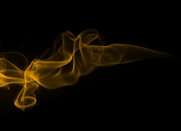 Yellow smoke abstract on black background drakness concept