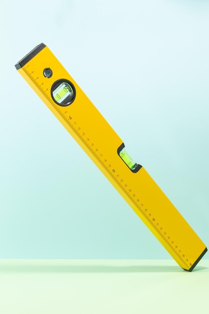 Photo yellow spirit level isolated on cyan and green background