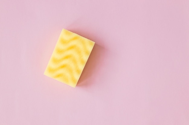 Yellow sponge and foam on pink background