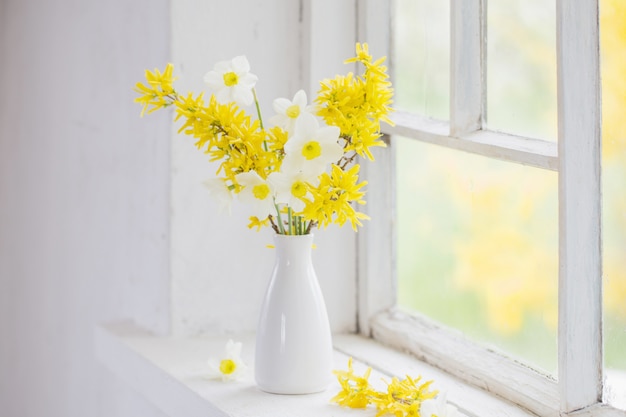 Yellow spring flowers on old white window