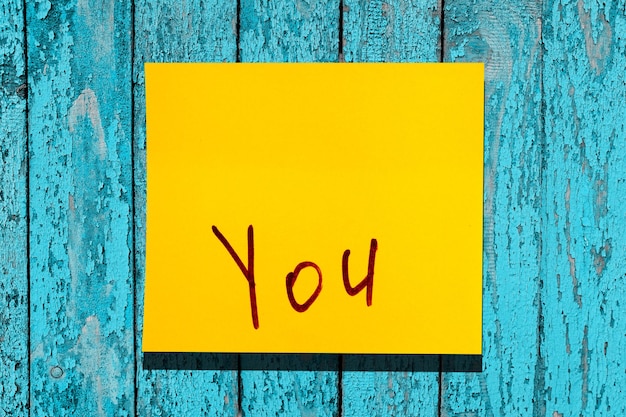 Yellow sticky leaf on the wall. inscription marker word you