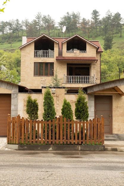 Yellow stone house with high front yard fence in Dilijan Armenia