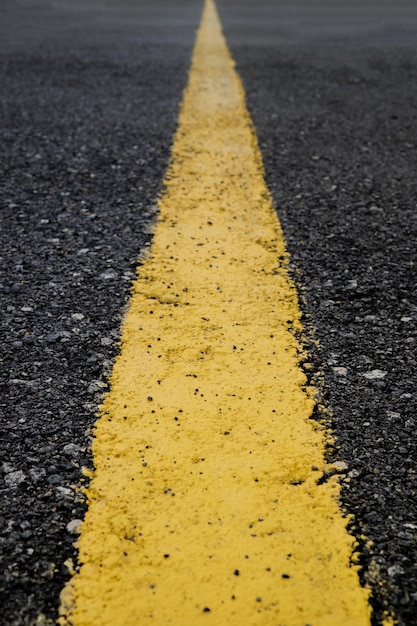 Yellow stripe on black asphalt background