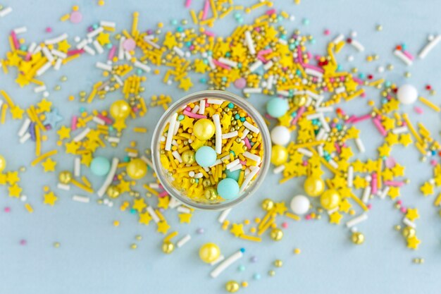 Yellow sugar sprinkles grainy on blue background closeup flat lay