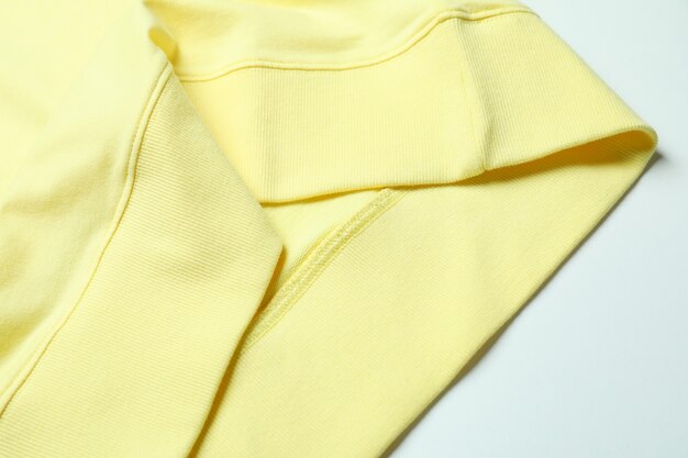 Yellow sweatshirt on white surface, close up