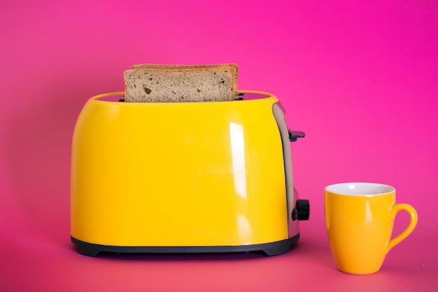 Photo yellow toaster on a pink background