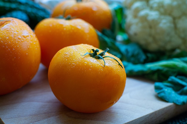 Yellow tomatoes on a background of cucumbers and cauliflower