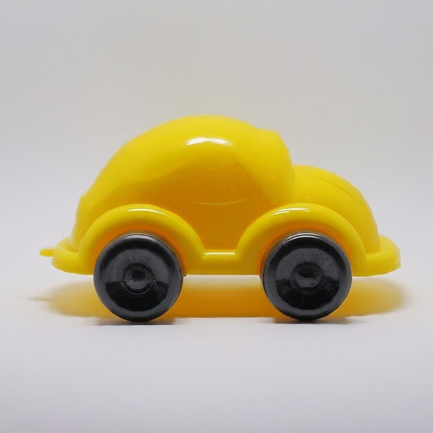 Photo a yellow toy car with the wheels on the top